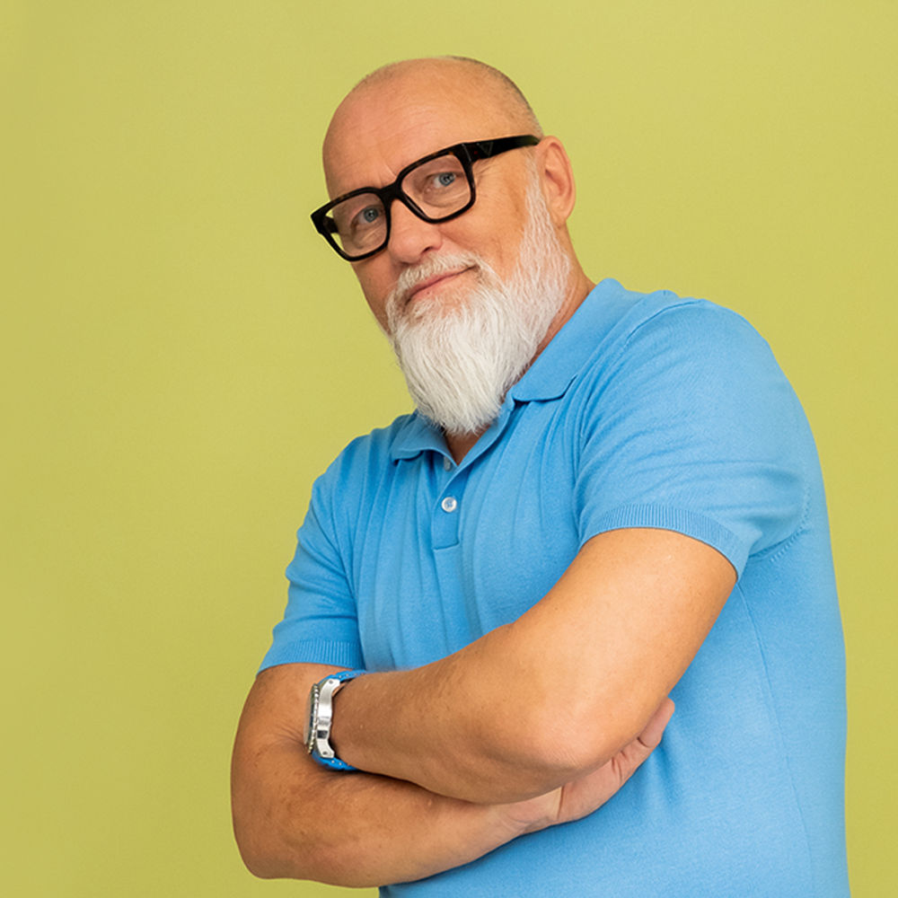 Büroleiter Frank in blauem Shirt auf gelbem Hintergrund